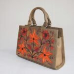 Stylish handbag with vibrant floral embroidery on a white background, perfect for fashion shoots.