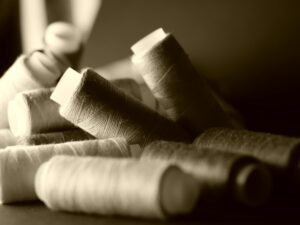 A detailed close-up of assorted colorful sewing threads with a shallow focus.